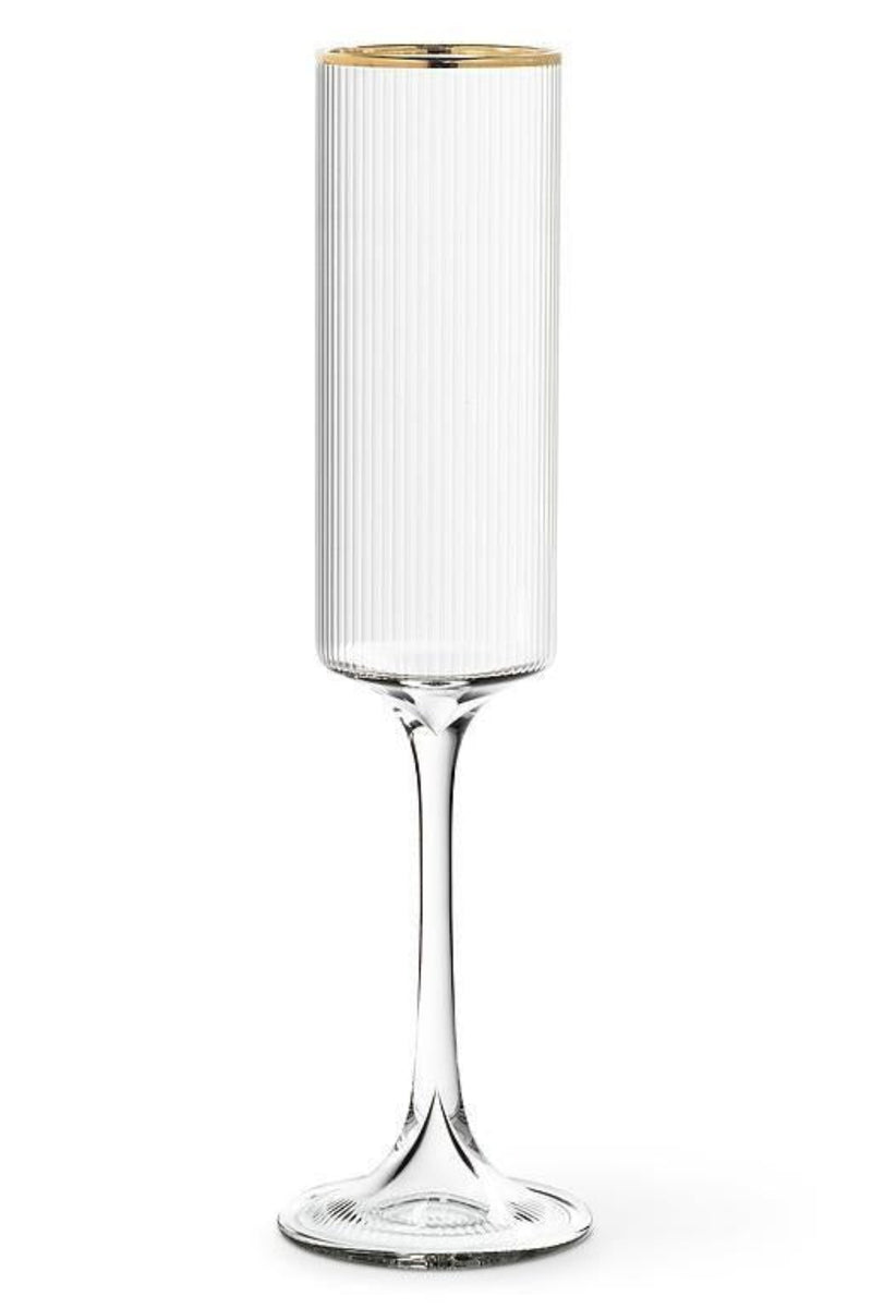 Clear glass flute with ribbed design and gold rim on a white background