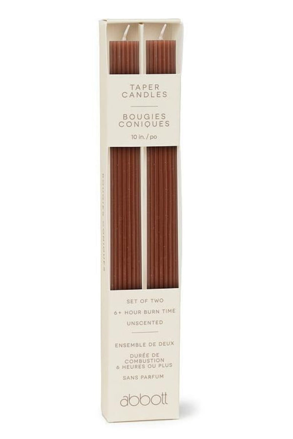 Two taper candles in a box on a white background