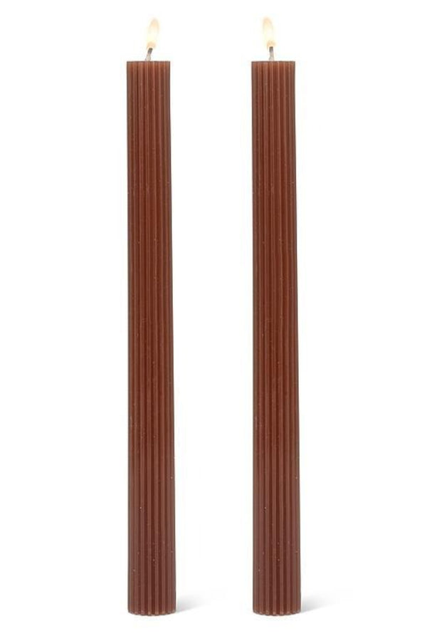 Two brown ribbed candles on a white background
