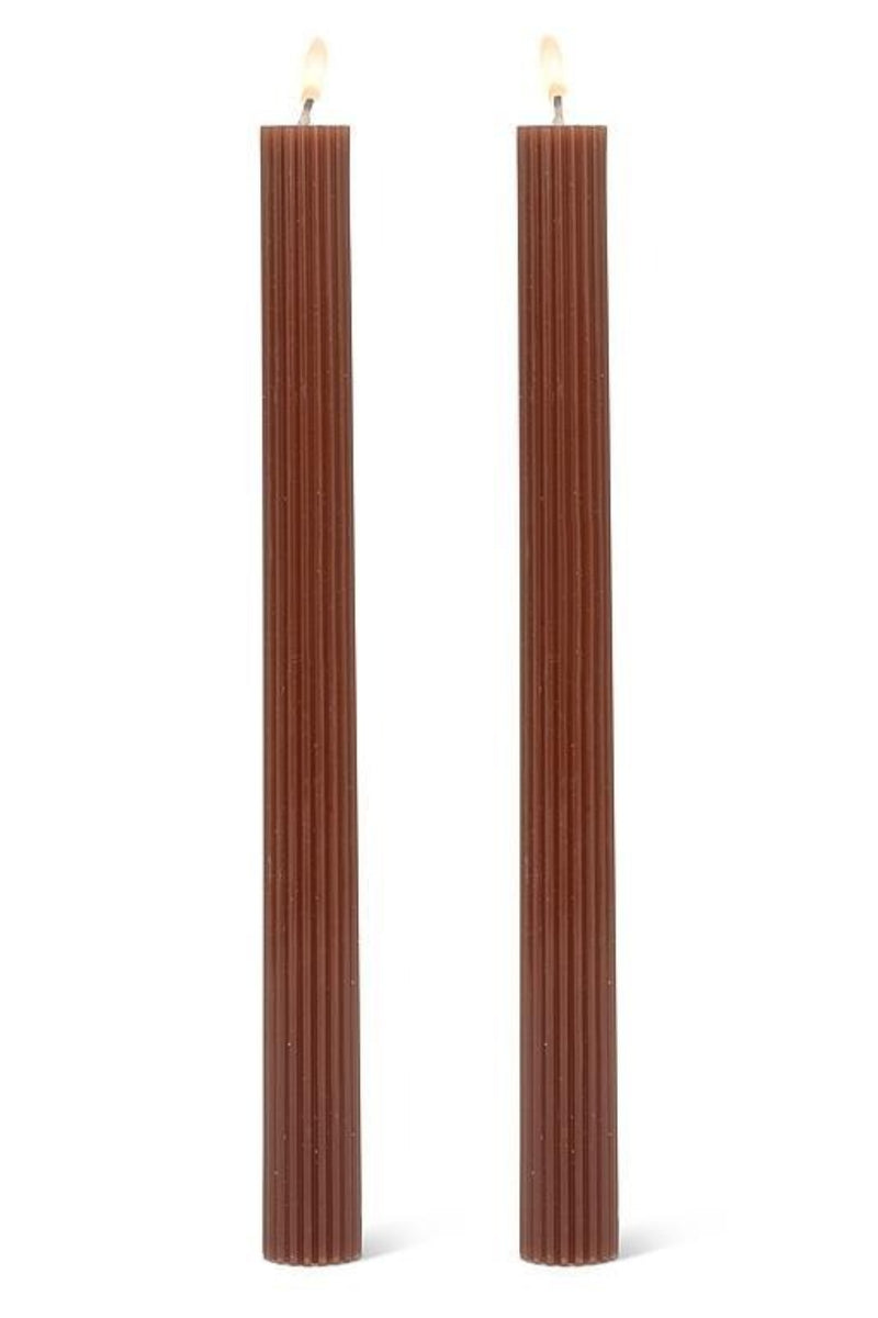 Two brown ribbed candles on a white background