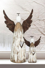 Two wooden angel figurines with wings against a window with a snowy scene.