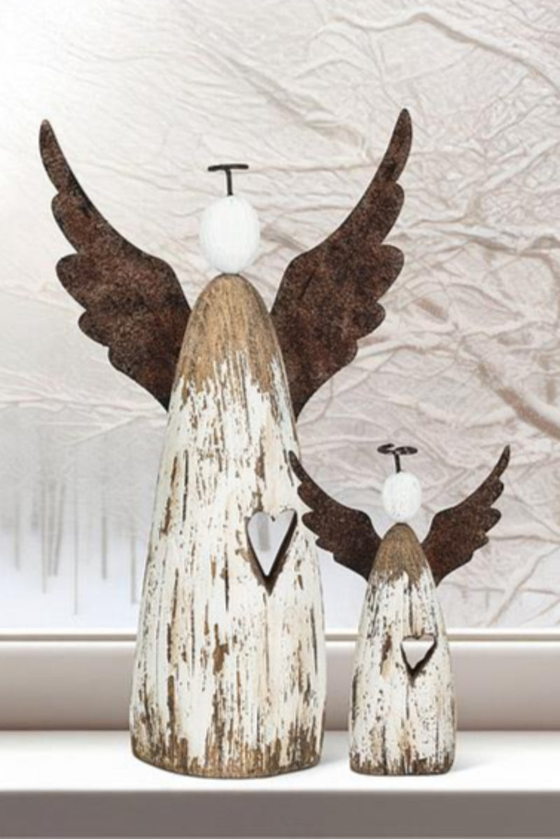 Two wooden angel figurines with wings against a window with a snowy scene.