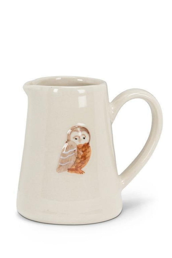 White ceramic pitcher with an owl design on a white background