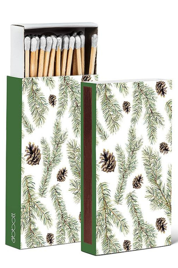 Matches with a decorative box featuring pine branches and cones on a white background