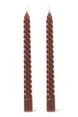 Two twisted brown candles on a white background