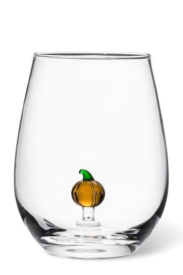 Clear glass with a small decorative pumpkin inside on a white background