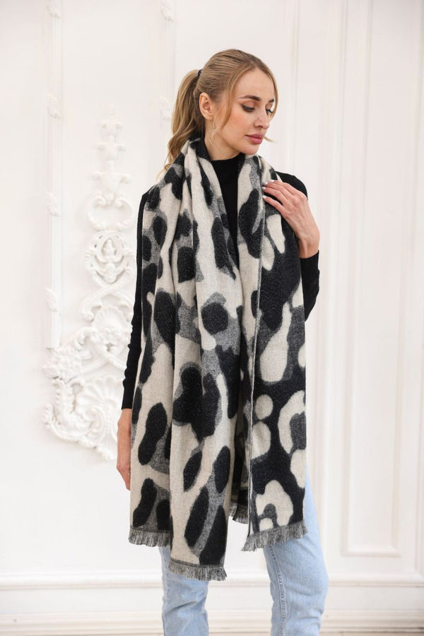 Woman wearing a black and white patterned scarf against a white background