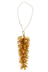 Brass pinecone ornament hanging against a white background