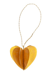Heart-shaped brass ornament with a string on a white background