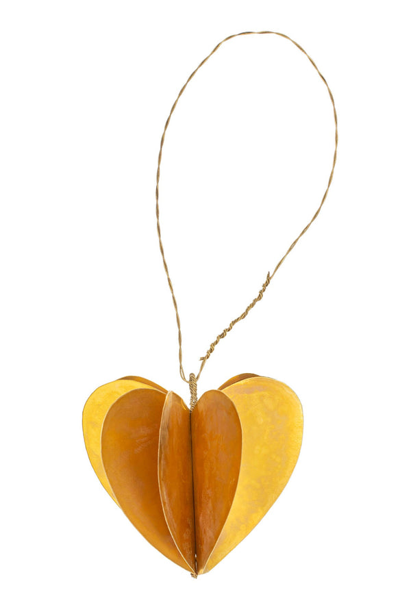 Heart-shaped brass ornament with a string on a white background