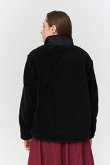 Person wearing a black fleece jacket on a white background