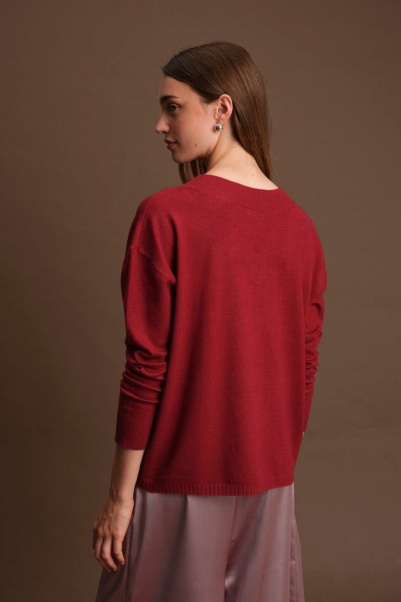 Woman wearing a red sweater against a brown background