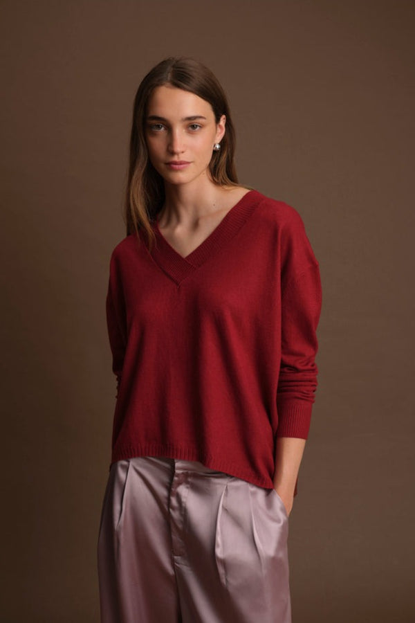 Woman wearing a red sweater against a brown background