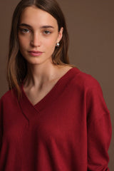Woman wearing a red sweater against a brown background
