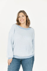 Woman wearing a striped sweater and jeans on a white background
