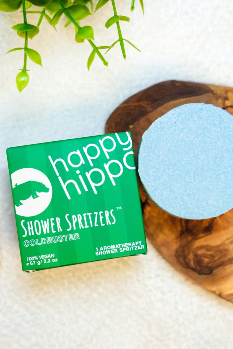 Happy Hippo Shower Spritzers packaging on a wooden surface.