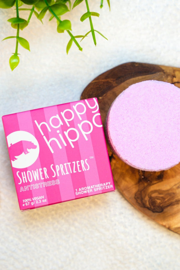 Happy Hippo Shower Spritzers packaging on a wooden board.