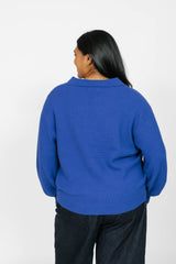 Person wearing a blue textured sweater on a white background