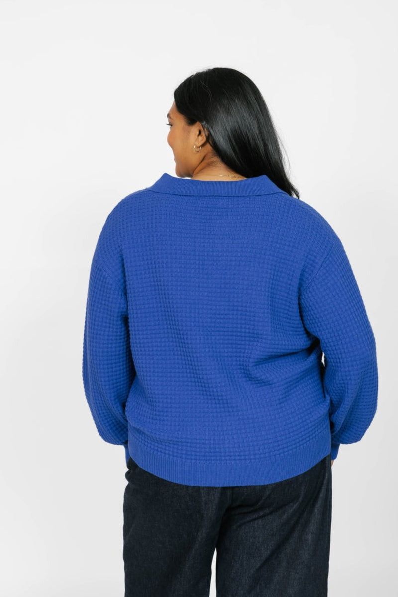 Person wearing a blue textured sweater on a white background