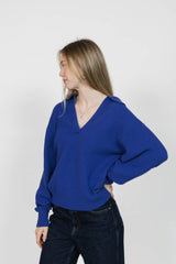 Woman wearing a blue sweater against a white background