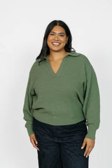 Woman wearing a green sweater against a white background