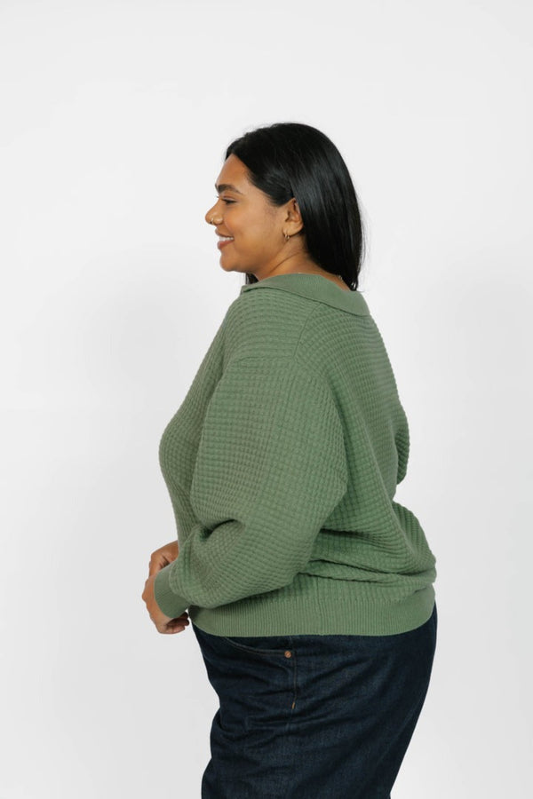 Woman wearing a green sweater against a white background