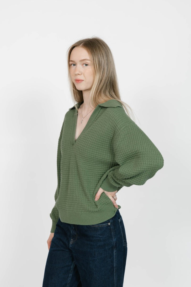 Woman wearing a green textured blouse against a white background