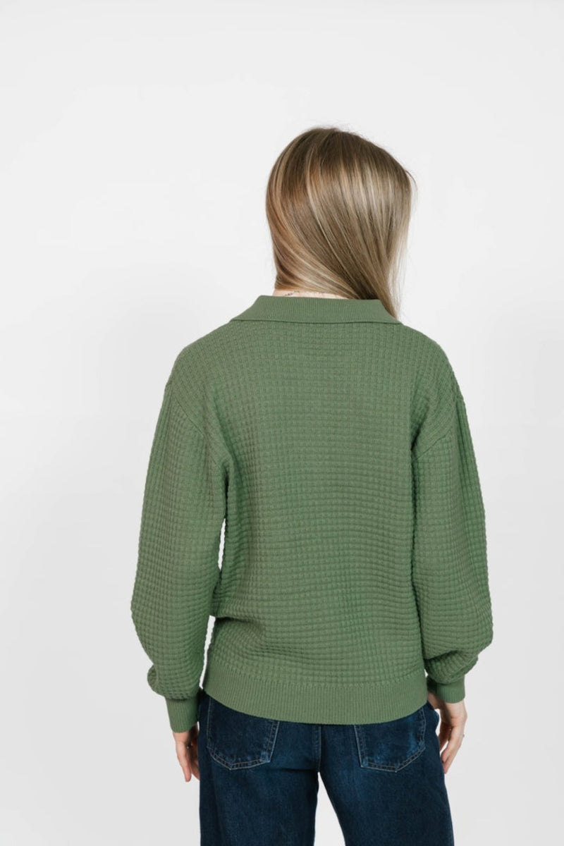 Person wearing a green checkered sweater on a white background
