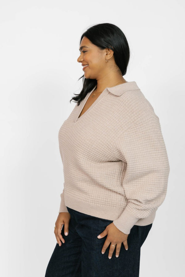 Woman wearing a beige sweater on a white background