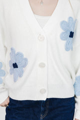 White cardigan with blue floral patterns worn by a person