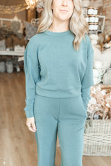 Woman wearing a green outfit in a cozy indoor setting