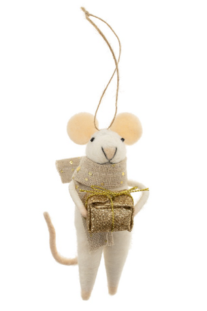 Felt mouse ornament hanging from a string wearing a beige scarf with gold dots holding a gold gift box on a white background