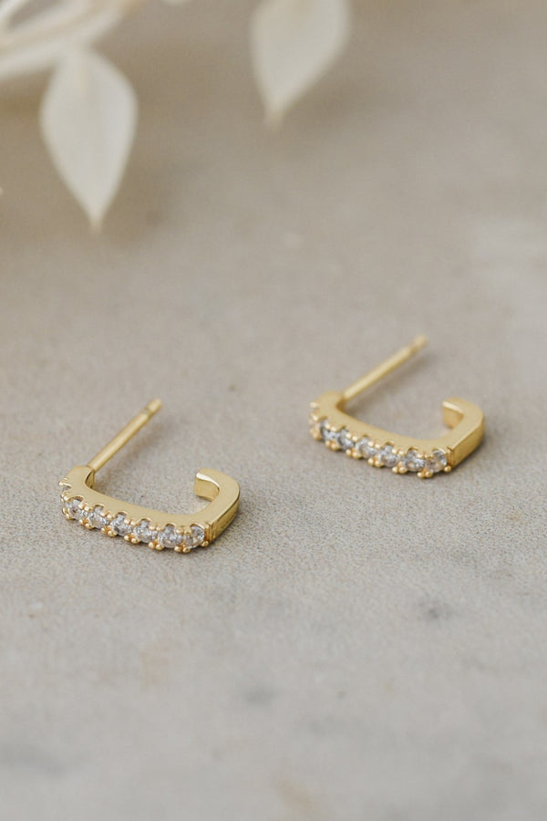 Gold hoop earrings with on a neutral background