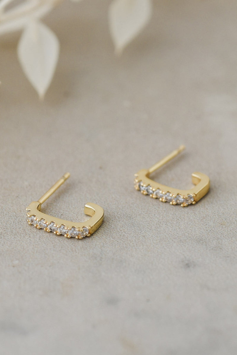Gold hoop earrings with on a neutral background