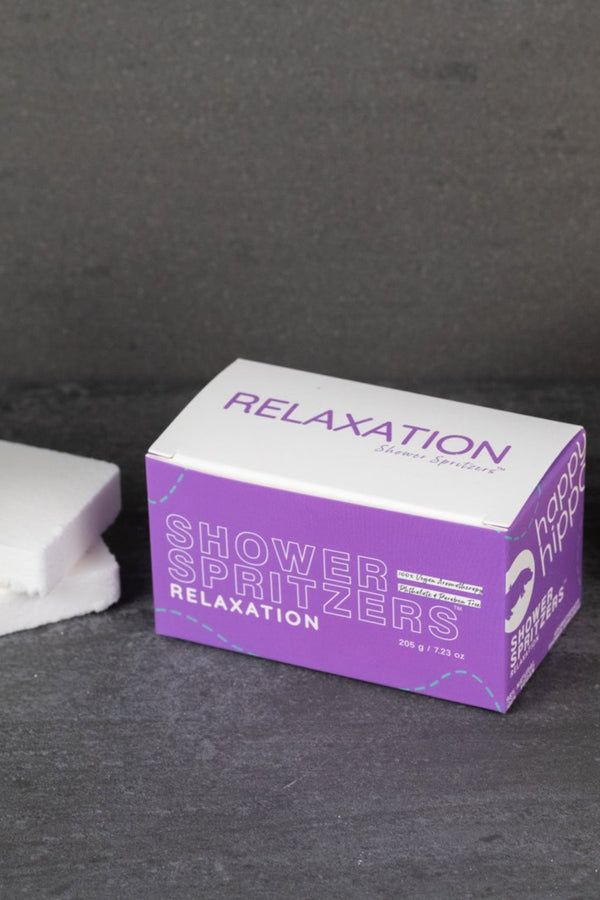 Box of 'Relaxation' Shower Spritzers on a dark surface.