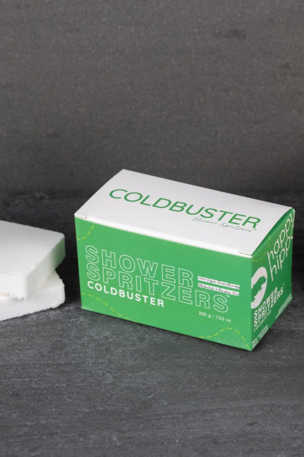 Box of COLDBUSTER Shower Spritzers on a dark surface.