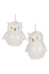 Two white owl ornaments with gold accents on a white background