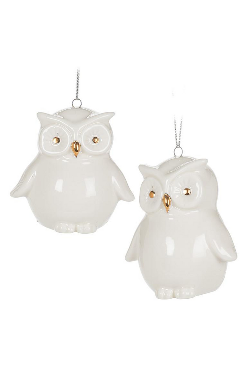 Two white owl ornaments with gold accents on a white background