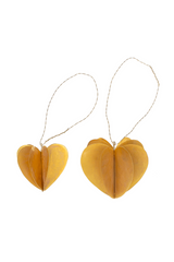Brass heart-shaped decorations with strings on a white background