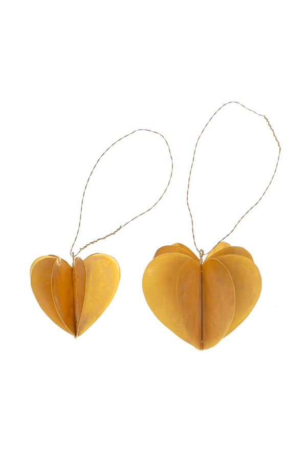 Brass heart-shaped decorations with strings on a white background