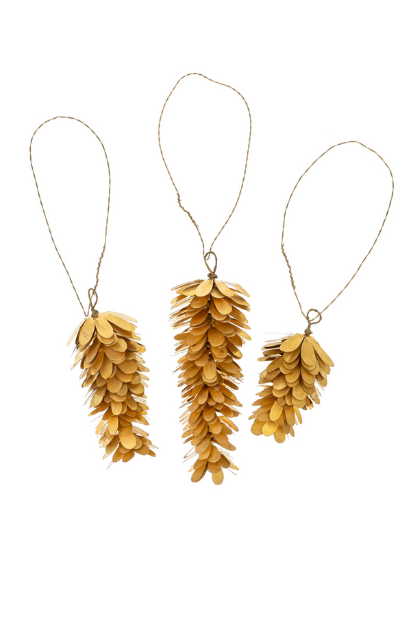 Three brass pine cone-shaped ornaments hanging on strings against a white background