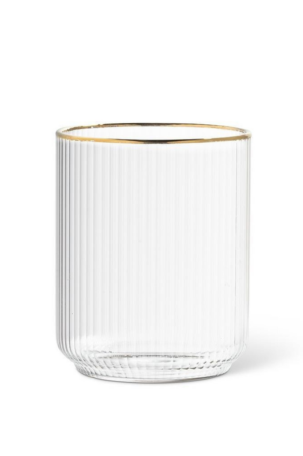 Clear ribbed glass tumbler with gold rim on a white background
