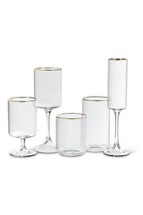 Set of clear ribbed glassware with gold rims on a white background