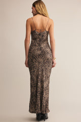 Woman wearing a leopard print dress with thin straps on a beige background