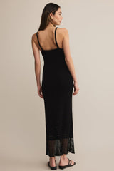 Woman wearing a black dress with lace hem on a beige background