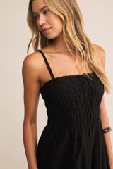 Woman wearing a black dress against a beige background
