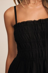 Black dress with thin straps on a neutral background