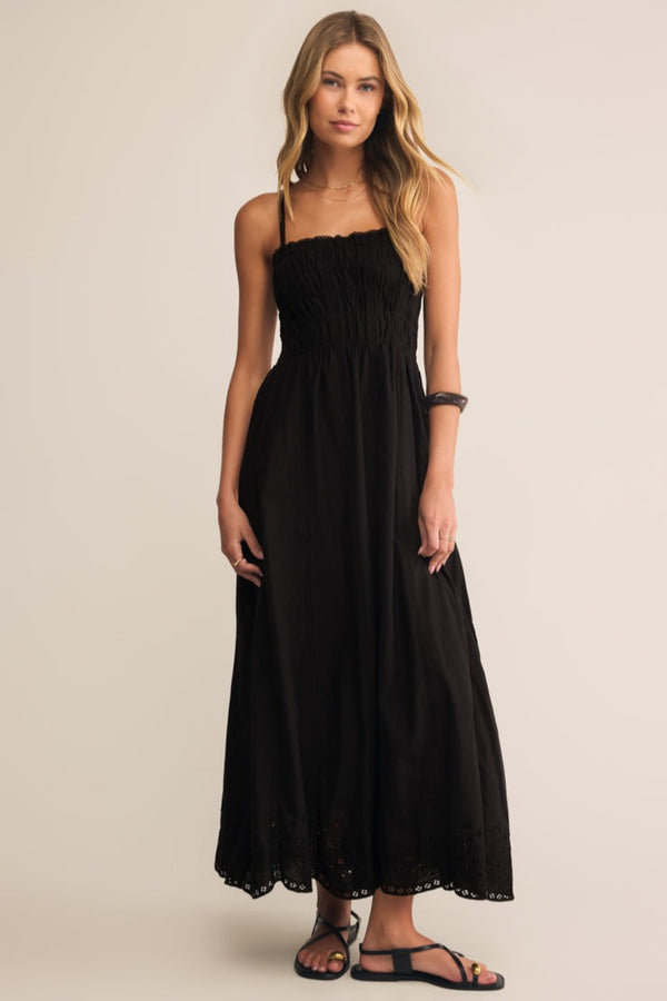 Woman wearing a black dress against a beige background