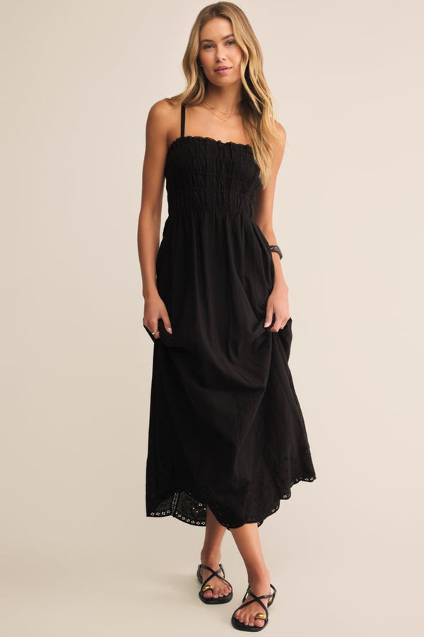Woman wearing a black dress against a beige background