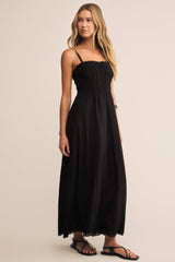 Woman wearing a black dress against a beige background
